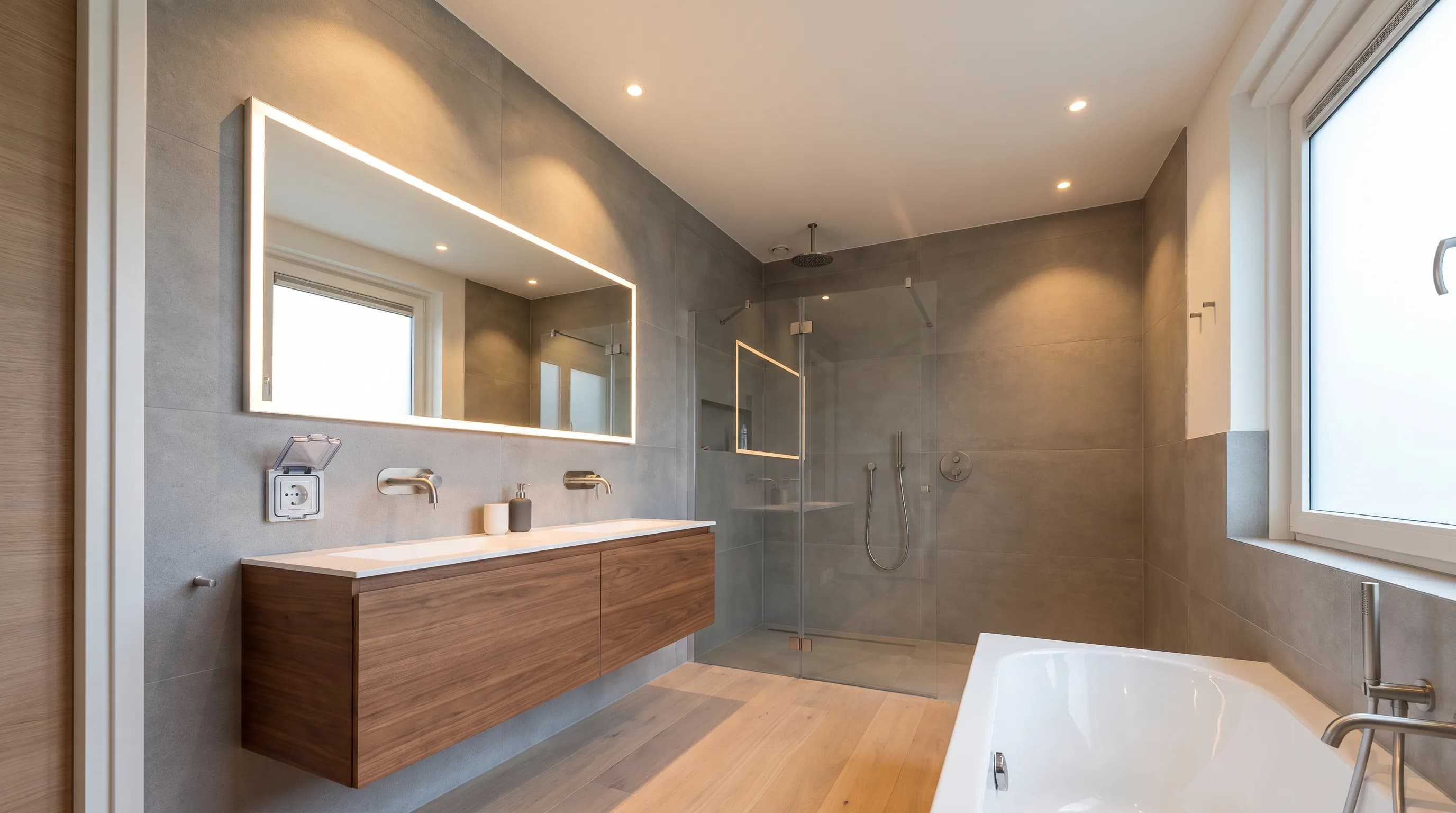 Moderne badkamer met spots, verlichte spiegel en een spatwaterdicht stopcontact