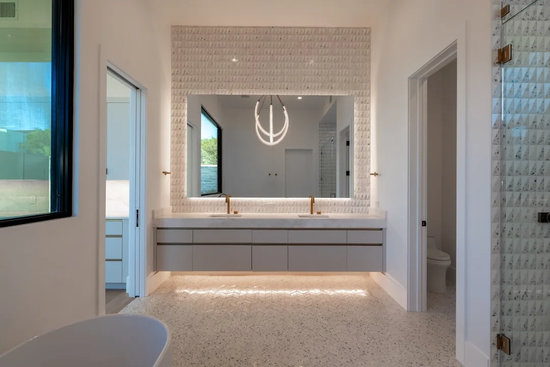 Lichte familiebadkamer met een brede dubbele wastafel en een groot verlicht spiegelvlak